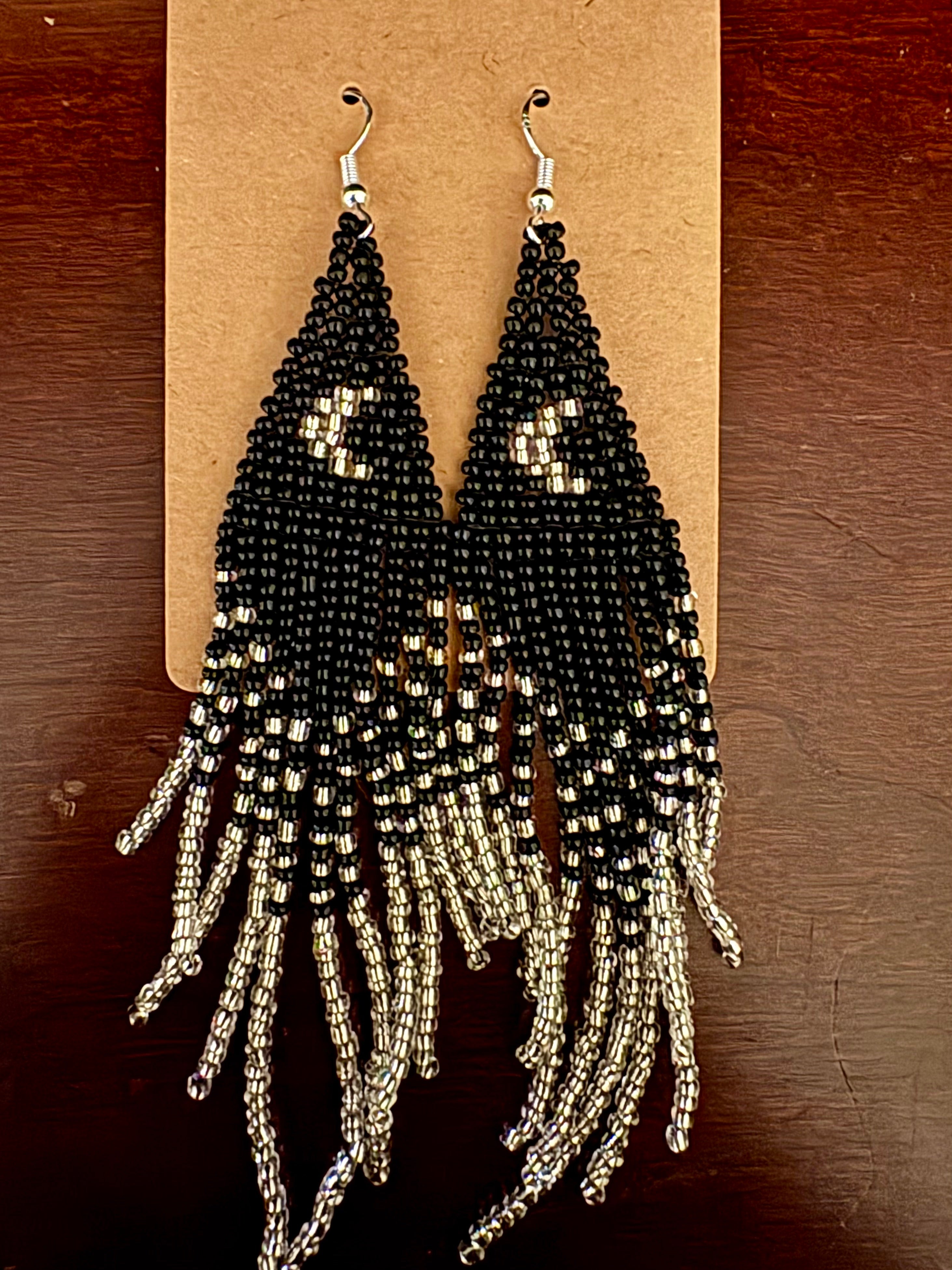Standing on the Moon beaded fringe earrings on dark wood surface