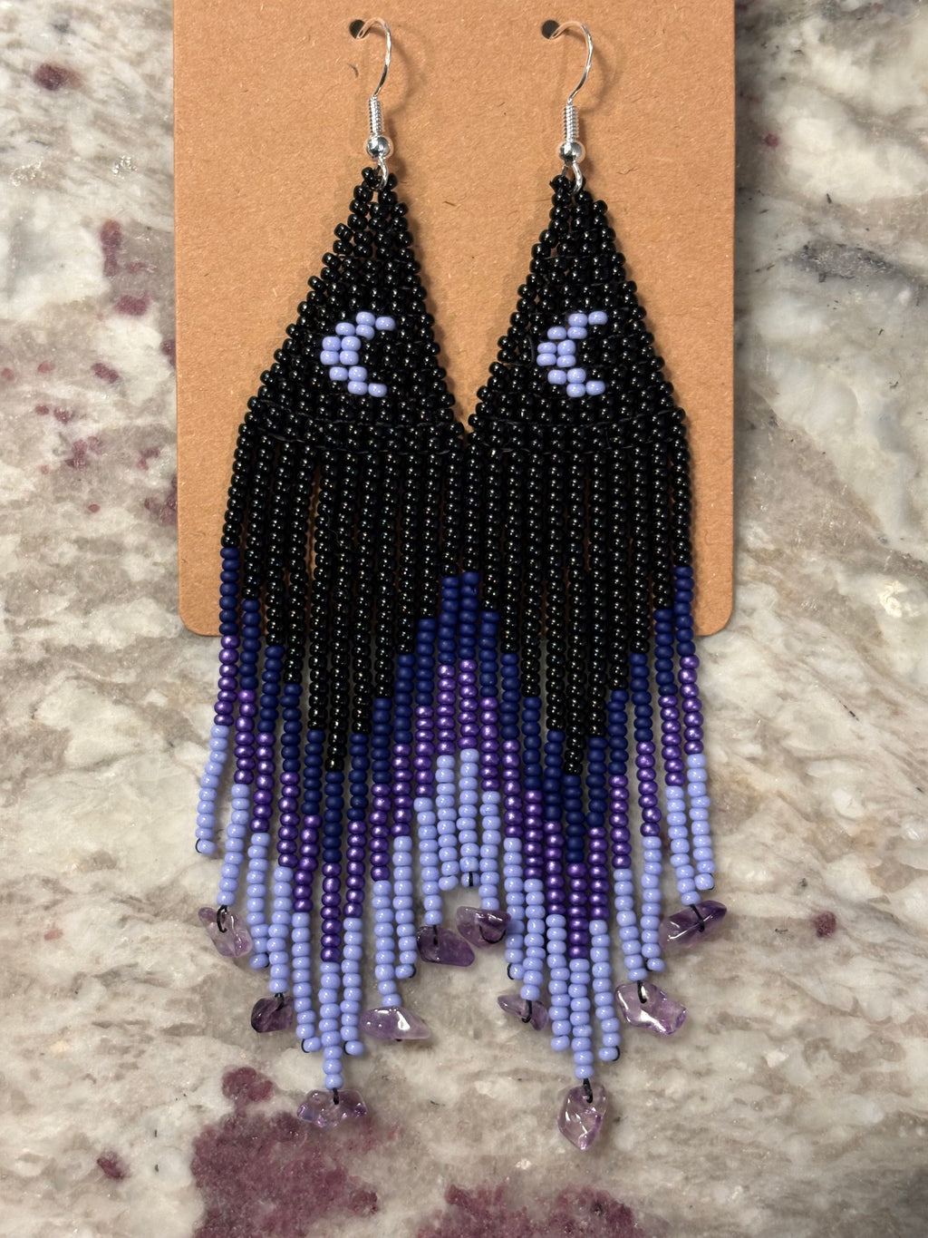 Purple Rain beaded fringe earrings on display card on marble